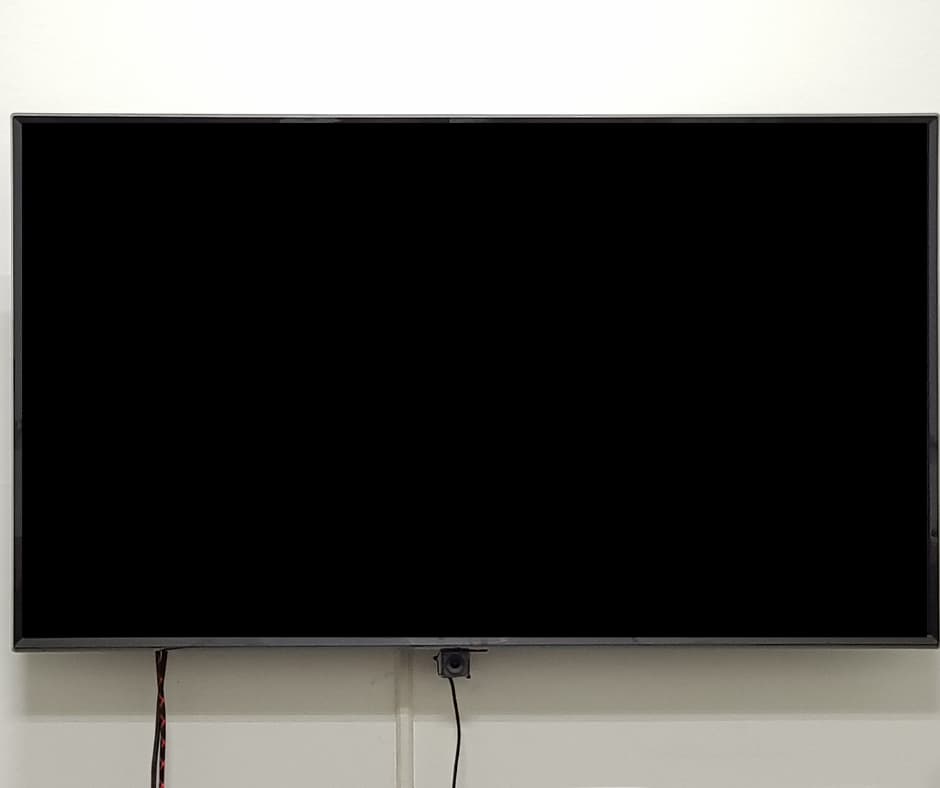 A modern tv mounted on a wall with a sound system